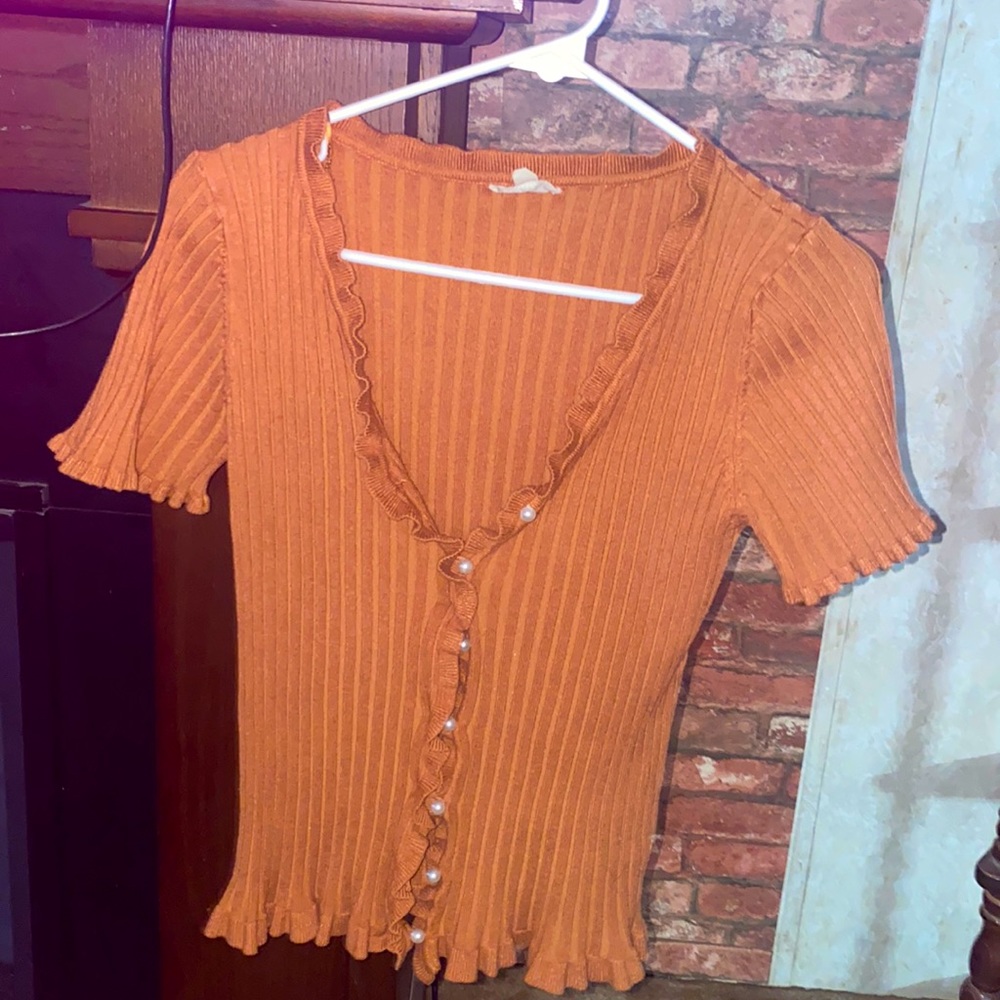 Brown blouse that has pearls in the front like buttons